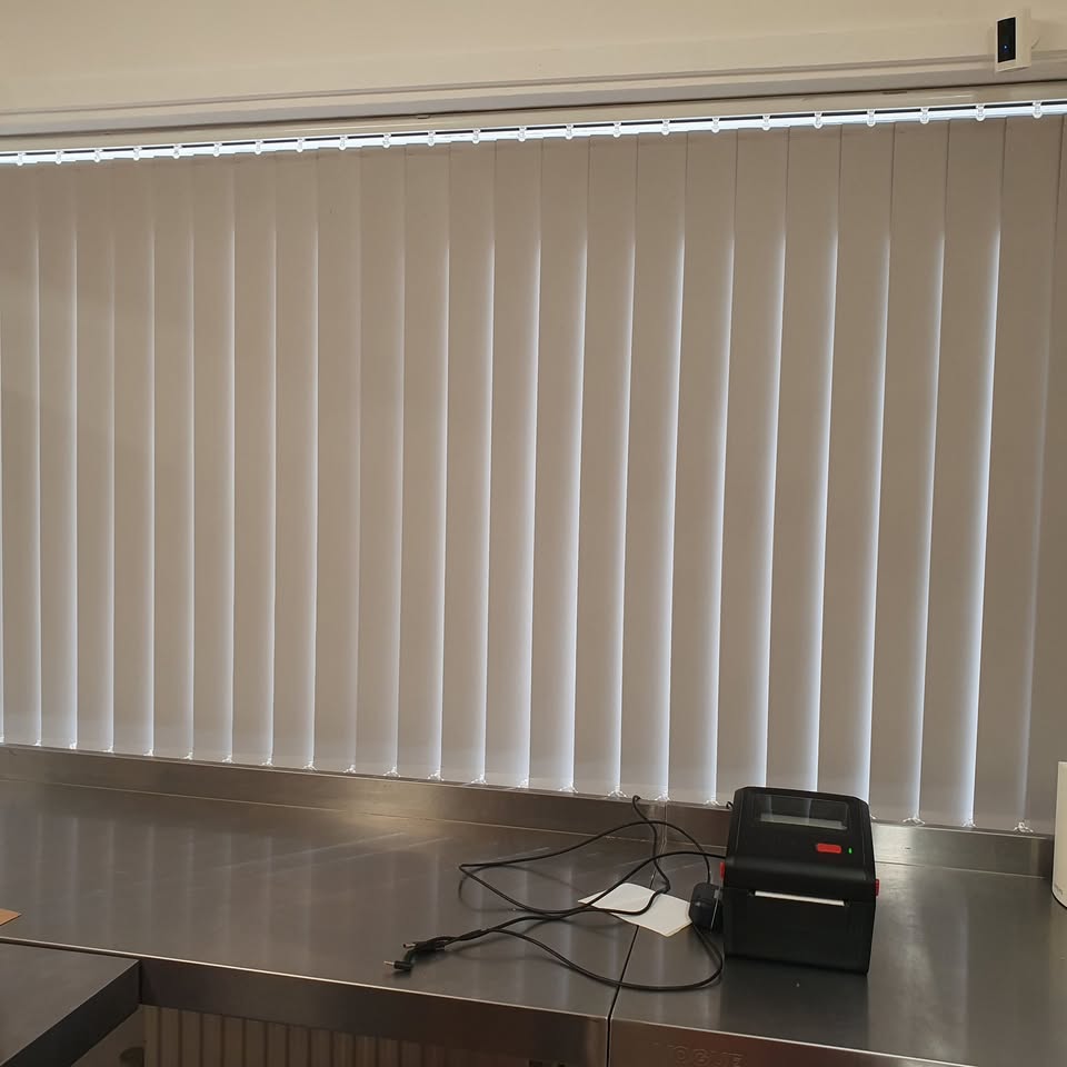 White vertical blinds across a wide window